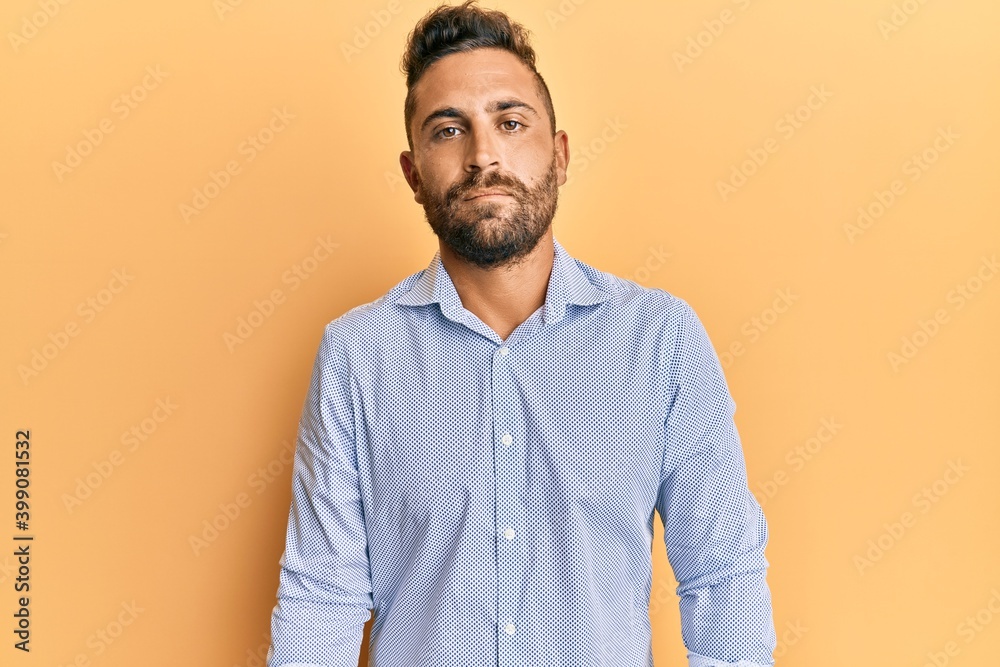 Handsome man with beard wearing casual clothes with serious expression on face. simple and natural looking at the camera. Handsome man with beard wearing casual clothes with serious expression on face. simple and natural looking at the camera.