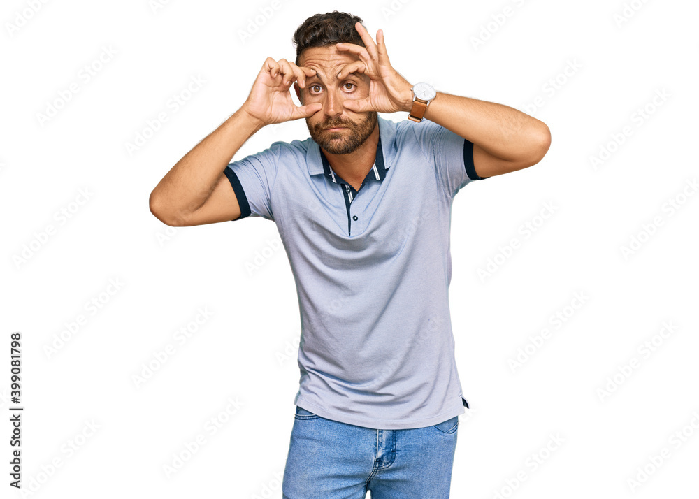 Handsome man with beard wearing casual clothes trying to open eyes with fingers, sleepy and tired for morning fatigue