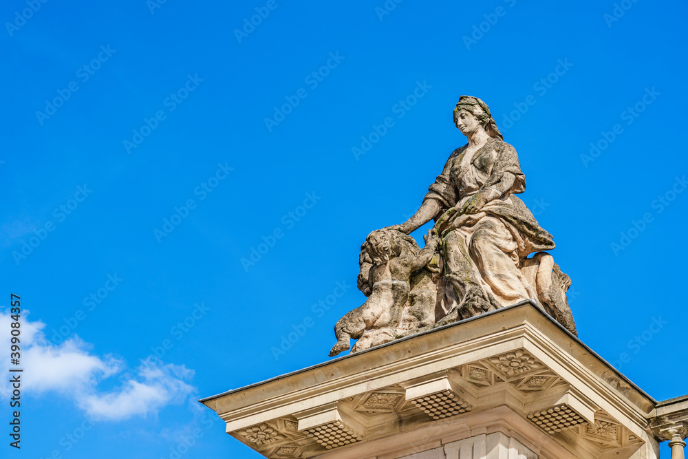 Decorative statue of a waman, child and lion on top pf the entrance gato to Palace Rohan in Strasbourg, Alsace region, France on a blue sky background Decorative statue of a waman, child and lion on top pf the entrance gato to Palace Rohan in Strasbourg, Alsace region, France on a blue sky background
