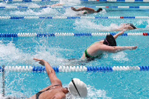 Wall Mural Motion blurred, Women Butterfly swimmers racing in a pool