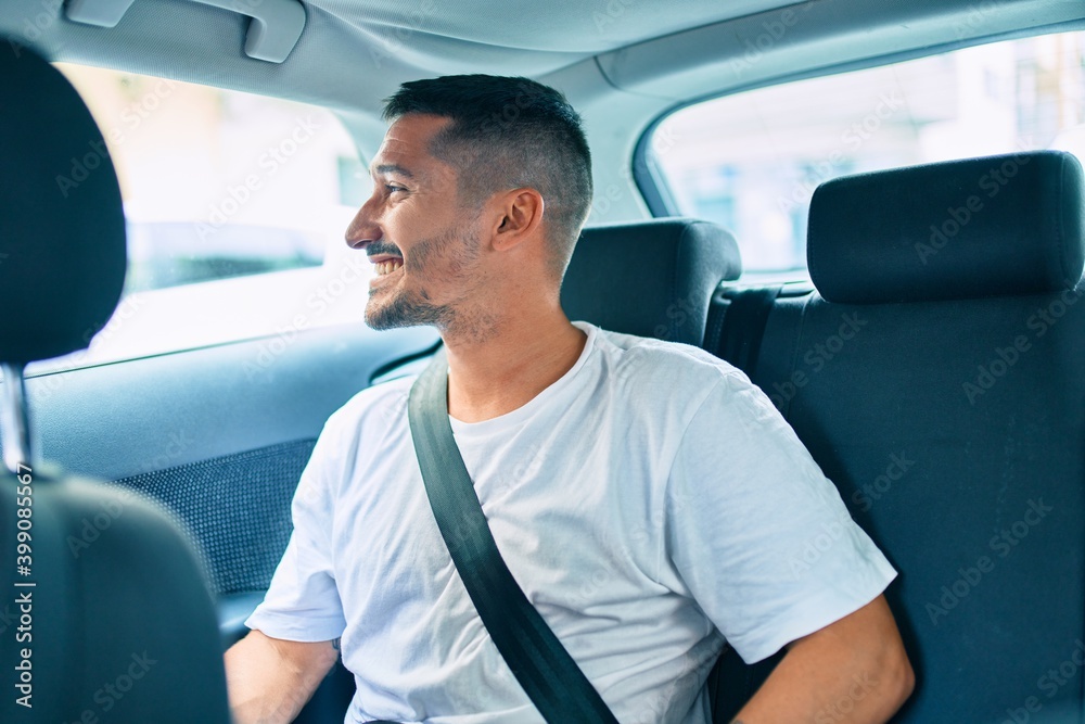 Young hispanic man smiling happy sitting on the car. Young hispanic man smiling happy sitting on the car.