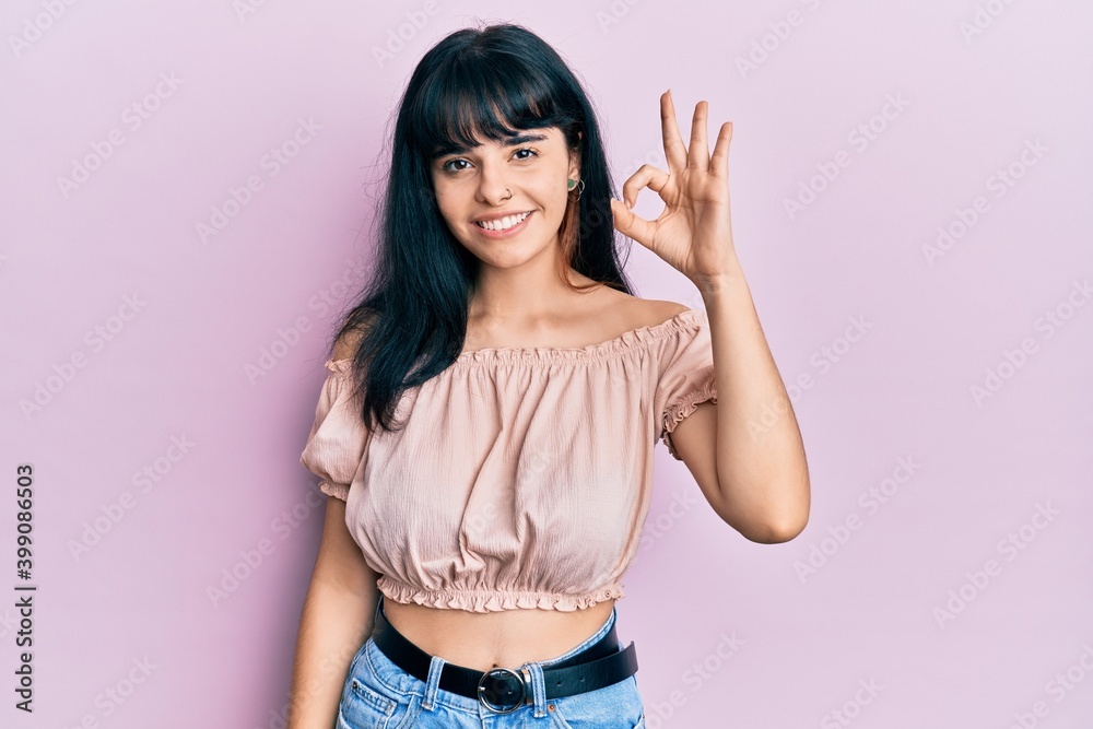 Young hispanic girl wearing casual clothes smiling positive doing ok sign with hand and fingers. successful expression. Young hispanic girl wearing casual clothes smiling positive doing ok sign with hand and fingers. successful expression.
