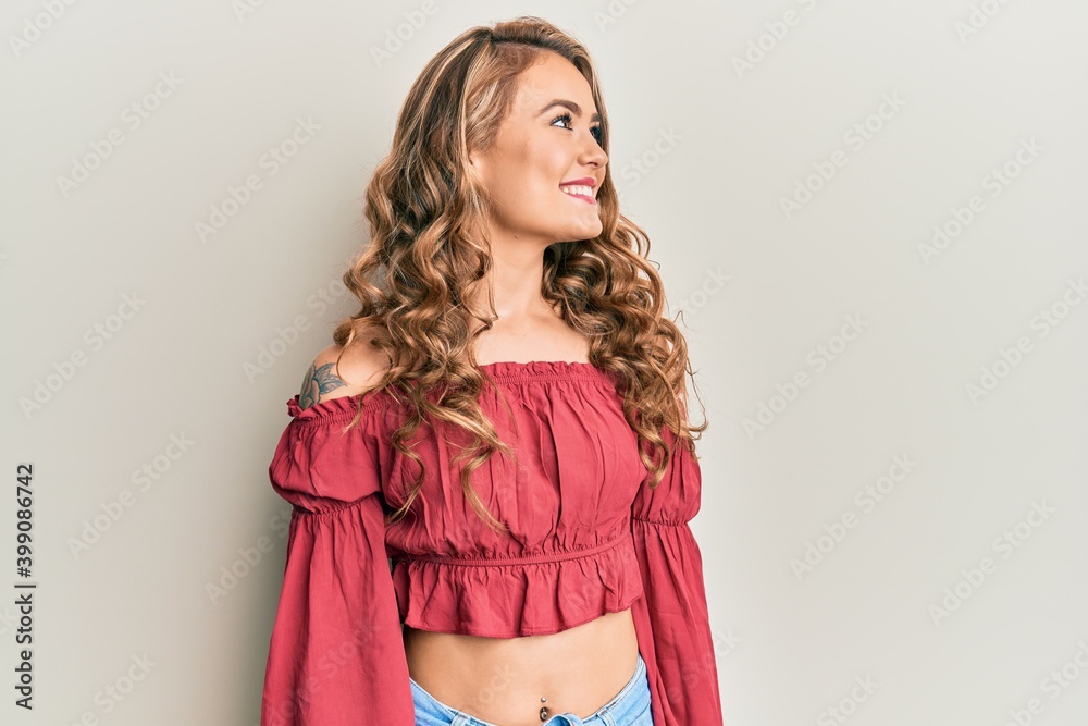Young blonde girl wearing casual clothes looking to side, relax profile pose with natural face and confident smile.
