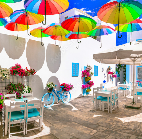 Fototapeta Naklejka Na Ścianę i Meble -  Beautiful street bar (restaurant) decoration with colorful umbrellas, vintage bicycle and flowers
