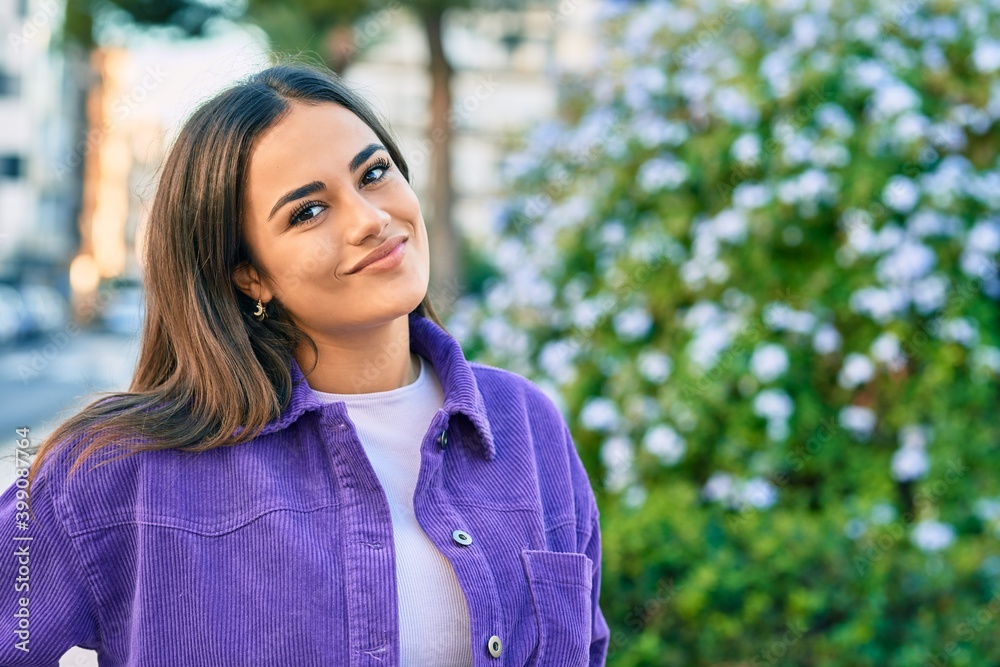 Young hispanic woman smiling happy walking at the park.