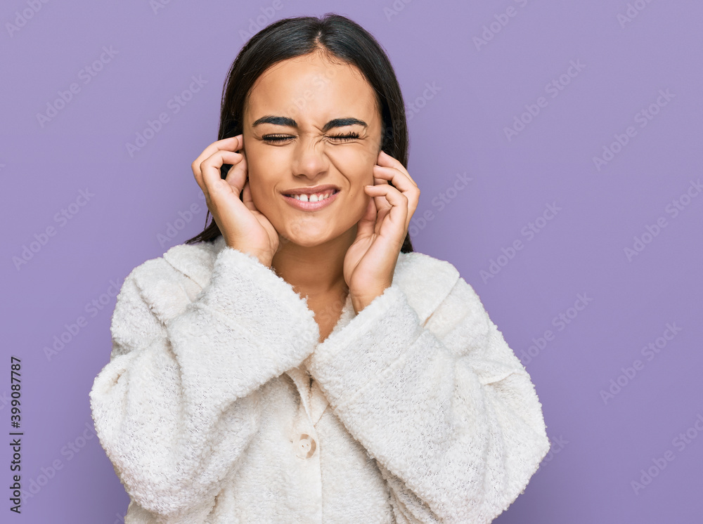 Young brunette woman wearing casual clothes covering ears with fingers with annoyed expression for the noise of loud music. deaf concept.