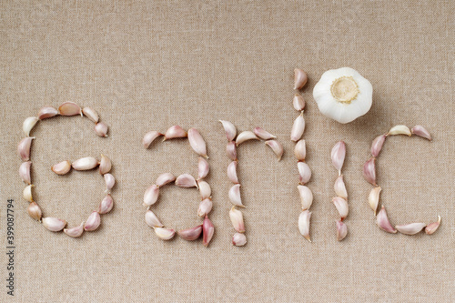 Garlic Cloves and Bulb in vintage organic woven basket on wooden background. spice is an herb that is grown around the world.