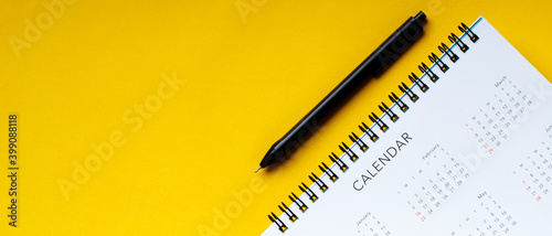 A pen with calendar on yellow background  photo