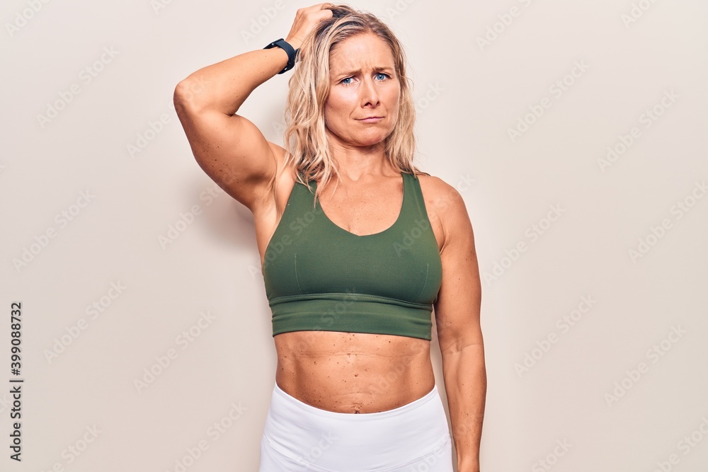 Middle age caucasian blonde woman wearing sportswear confuse and wonder about question. uncertain with doubt, thinking with hand on head. pensive concept. Middle age caucasian blonde woman wearing sportswear confuse and wonder about question. uncertain with doubt, thinking with hand on head. pensive concept.