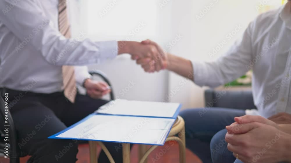 Medium close up shot slowmotion of insurance sale man shake hands with elderly couple customer after close deal and signed agreement at customer home.