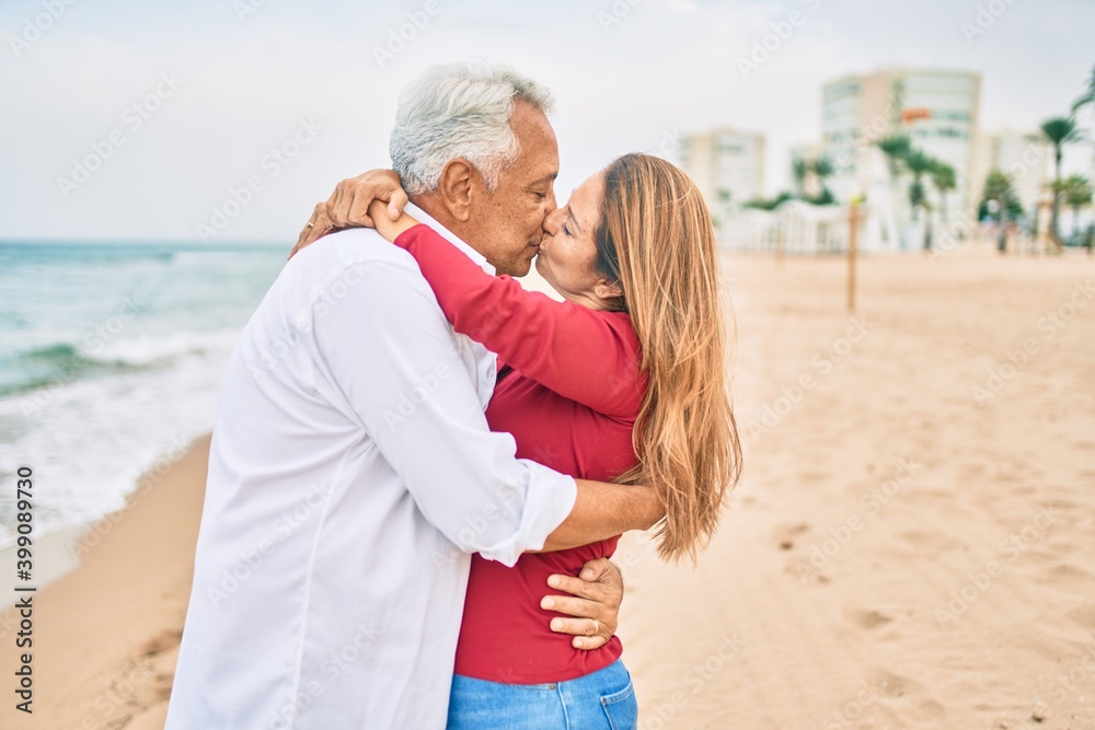 Middle age hispanic couple kissing and hugging at the beach Middle age hispanic couple kissing and hugging at the beach