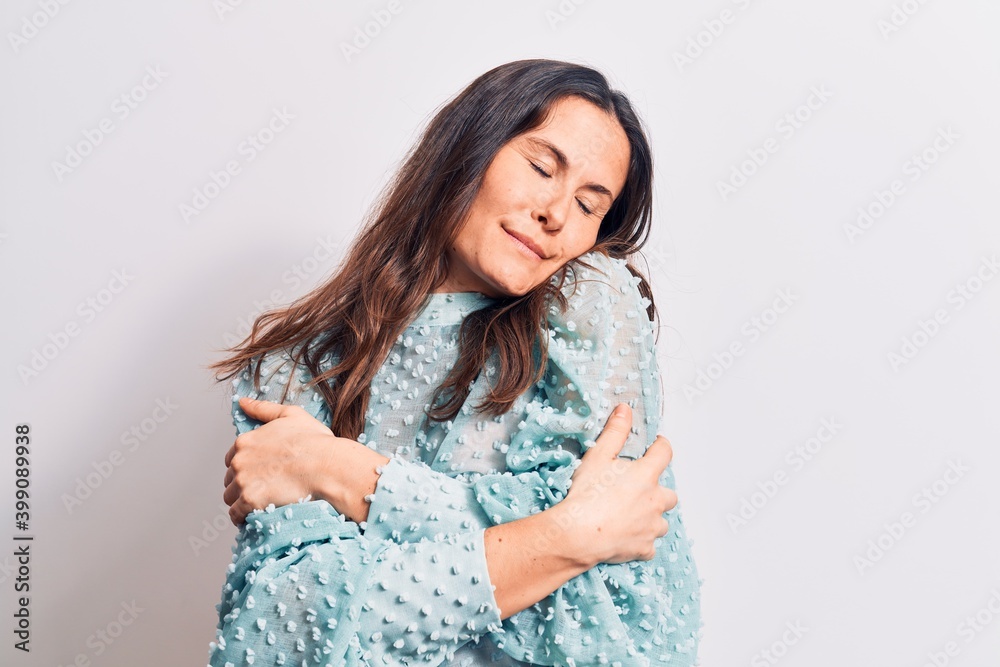 Young beautiful brunette woman wearing casual t-shirt standing over isolated white background hugging oneself happy and positive, smiling confident. Self love and self care Young beautiful brunette woman wearing casual t-shirt standing over isolated white background hugging oneself happy and positive, smiling confident. Self love and self care
