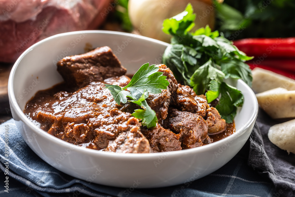 Plateful of of meat stew or a goulash with celery tops Plateful of of meat stew or a goulash with celery tops