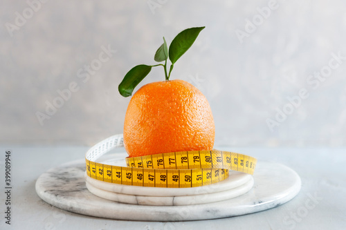 Orange citrus fruit and centimeter. Fresh fruit, concept for weight loss, diet, ketogenic diet, intermittent fasting photo