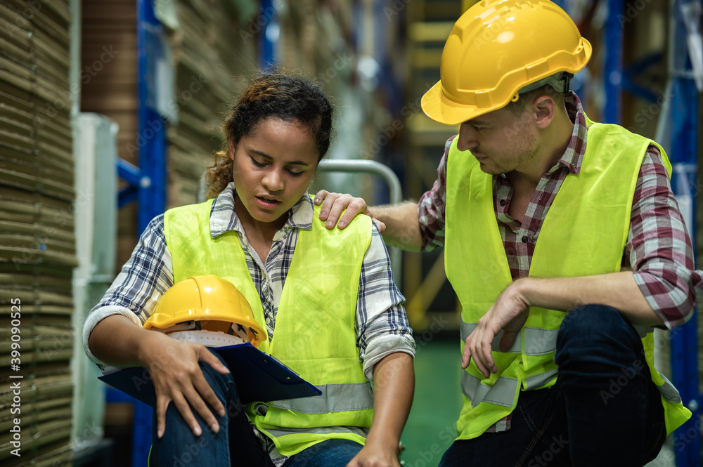 Young African female warehouse worker staff feeling sad and stress while Caucasian man consoling and encouraging due to been fired from job cause by company bankruptcy from coronavirus pandemic. Young African female warehouse worker staff feeling sad and stress while Caucasian man consoling and encouraging due to been fired from job cause by company bankruptcy from coronavirus pandemic.