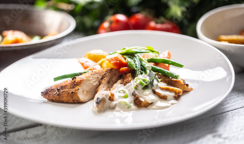 Chicken breasts cooked with fresh vegetable and served with a mushroom sauce on a plate