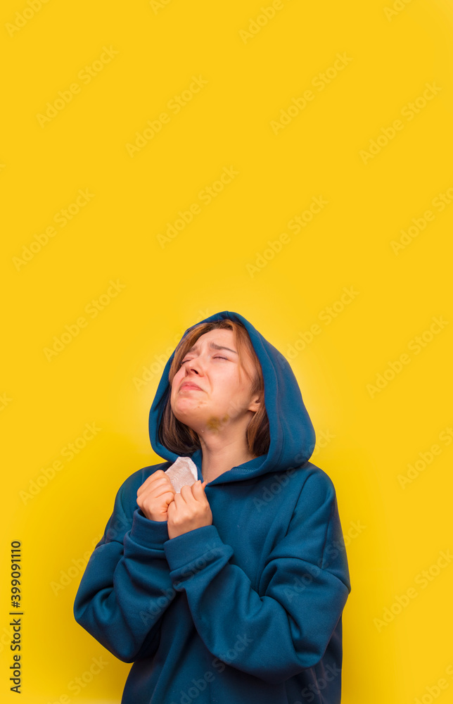 Girl in purple sweatshirt crying on yellow background. Close up studio portrait. Copy, empty space for text. Girl in purple sweatshirt crying on yellow background. Close up studio portrait. Copy, empty space for text.