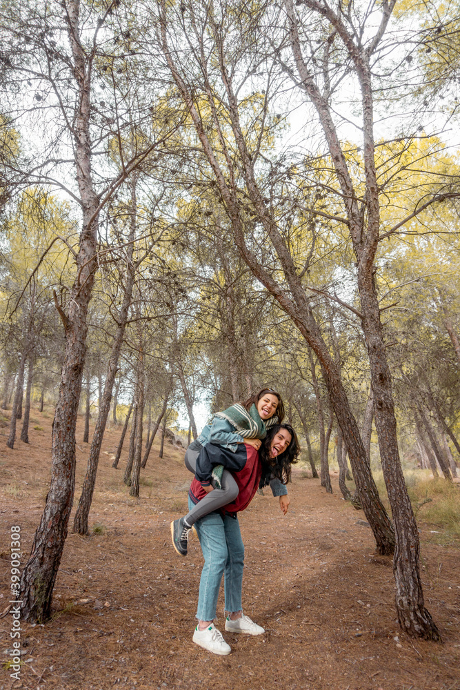 Lesbian couple sticking out her tongue as a sign of protest and attitude in nature. Autumn and vintage landscape