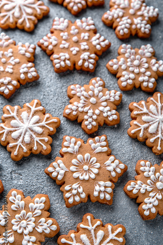 Christmas homemade gingerbread cookies in the shape of snowflakes and herringbone on a blue background. Holiday sweets for decoration and gifts.