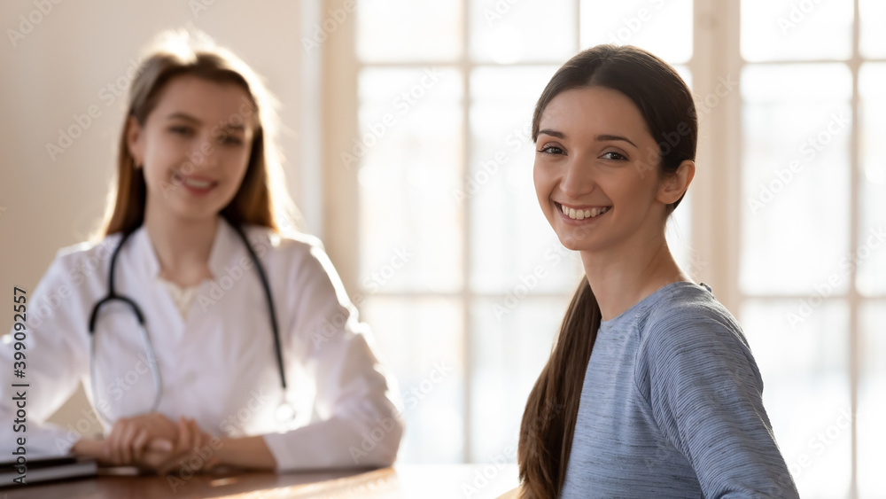 Φωτογραφία Wide panoramic view of satisfied young Caucasian female patient feel happy after consultation with doctor in private clinic