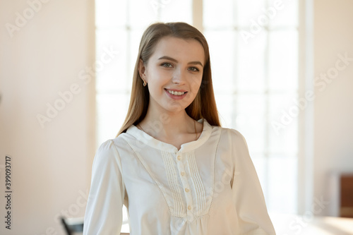 Headshot portrait of smiling young Caucasian woman patient satisfied with good quality medical service in clinic. Profile picture of happy female client pose in private hospital. Healthcare concept.