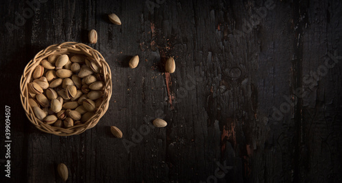 Pistachio in basket on a dark wooden background