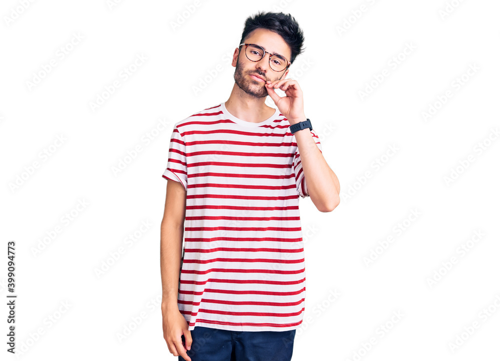 Young hispanic man wearing casual clothes mouth and lips shut as zip with fingers. secret and silent, taboo talking Young hispanic man wearing casual clothes mouth and lips shut as zip with fingers. secret and silent, taboo talking