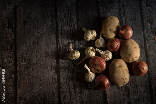 onion, potato and garlic vegetable on dark wooden background