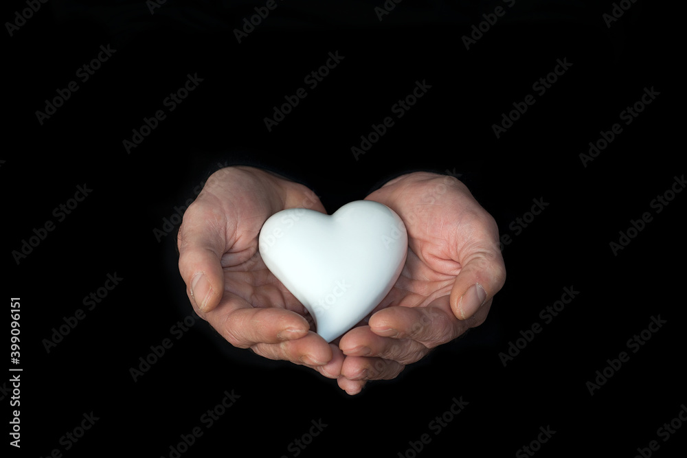 Male hands on a dark background, showing hand with white Heart. Power of hope or love and devotion. hands with faith in religion and belief in God. Male hands on a dark background, showing hand with white Heart. Power of hope or love and devotion. hands with faith in religion and belief in God.