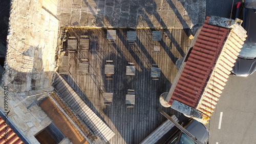 Картината върху платно Vista aérea cenital de una terraza de madera con mesas y sillas y un hórreo gall