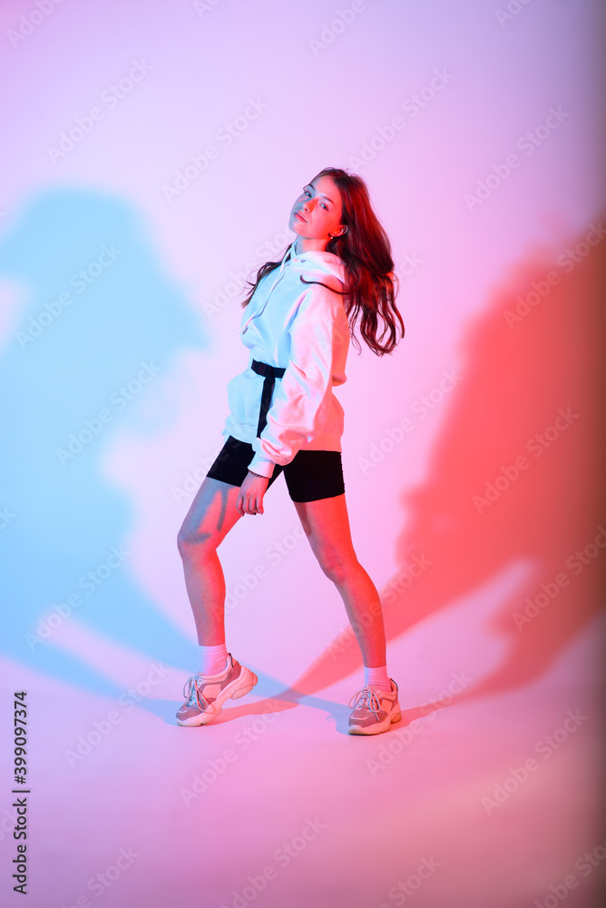 Young beautiful dancer posing on a studio background