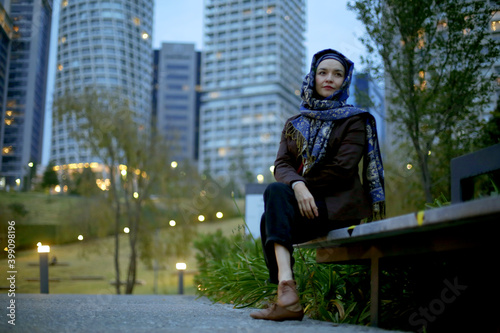 Medium shot pictures of beautiful model using hijab with office buildings in the back