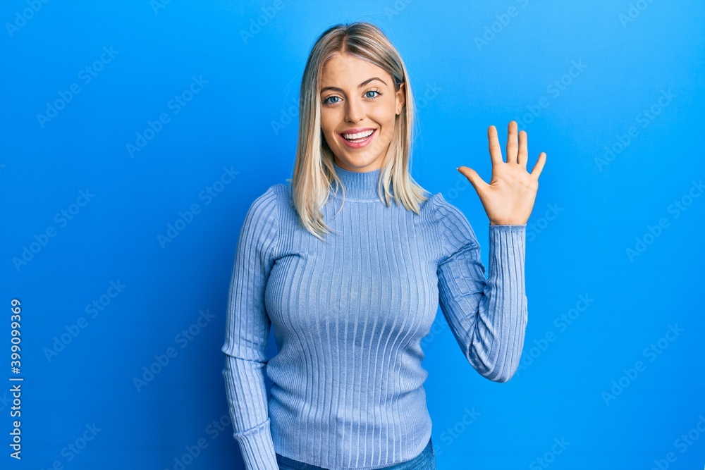 Beautiful blonde woman wearing casual clothes showing and pointing up with fingers number five while smiling confident and happy. Beautiful blonde woman wearing casual clothes showing and pointing up with fingers number five while smiling confident and happy.