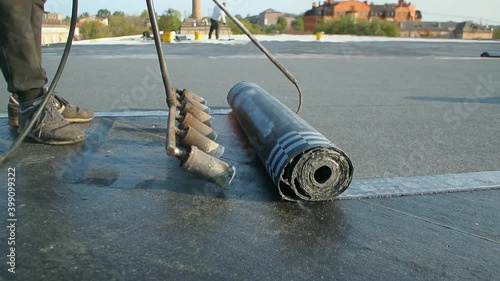 Roofer team lay black roofing material on white flat roof. Aerial view pattern texture concrete