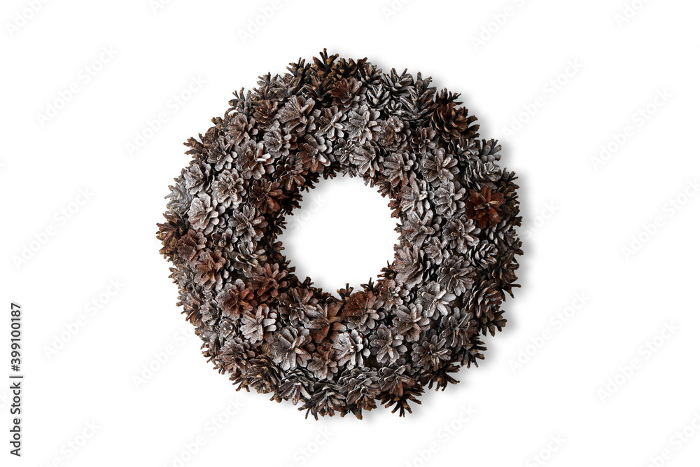 A Christmas wreath of cones hangs on a white wall A Christmas wreath of cones hangs on a white wall