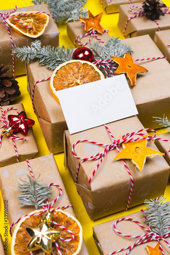 New year gift card, visitcard mockup with many presents and christmas eco decor on yellow background