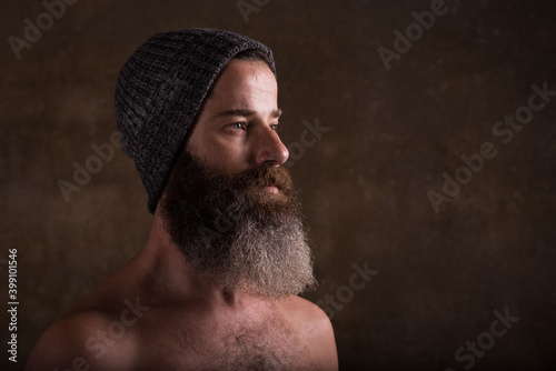 studio photography of bearded man shirtless in dim light