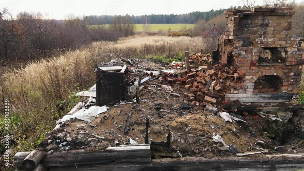 A smooth flight along a completely burnt-out building with a red brick oven. Old ruins, aftermath of a fire, gloomy look. Cloudy autumn day, yellowed grass. Aerial wide angle view. Warm soft light. A smooth flight along a completely burnt-out building with a red brick oven. Old ruins, aftermath of a fire, gloomy look. Cloudy autumn day, yellowed grass. Aerial wide angle view. Warm soft light.