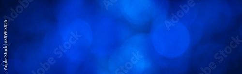 blue abstract background banner with blue bokeh light effect in the dark with copy space