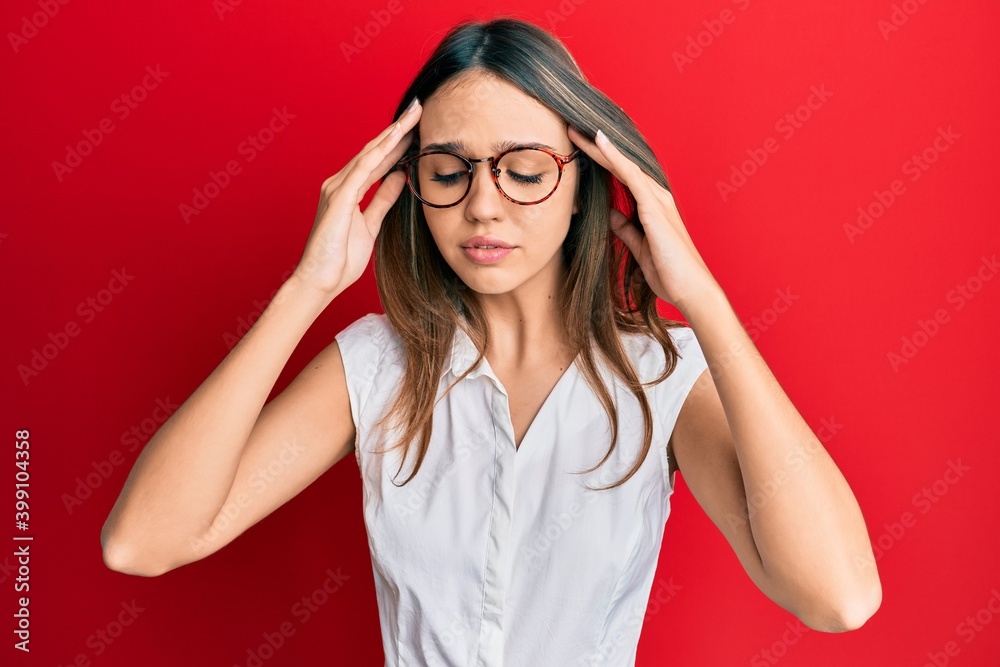 Young brunette woman wearing casual clothes and glasses with hand on head for pain in head because stress. suffering migraine. Young brunette woman wearing casual clothes and glasses with hand on head for pain in head because stress. suffering migraine.