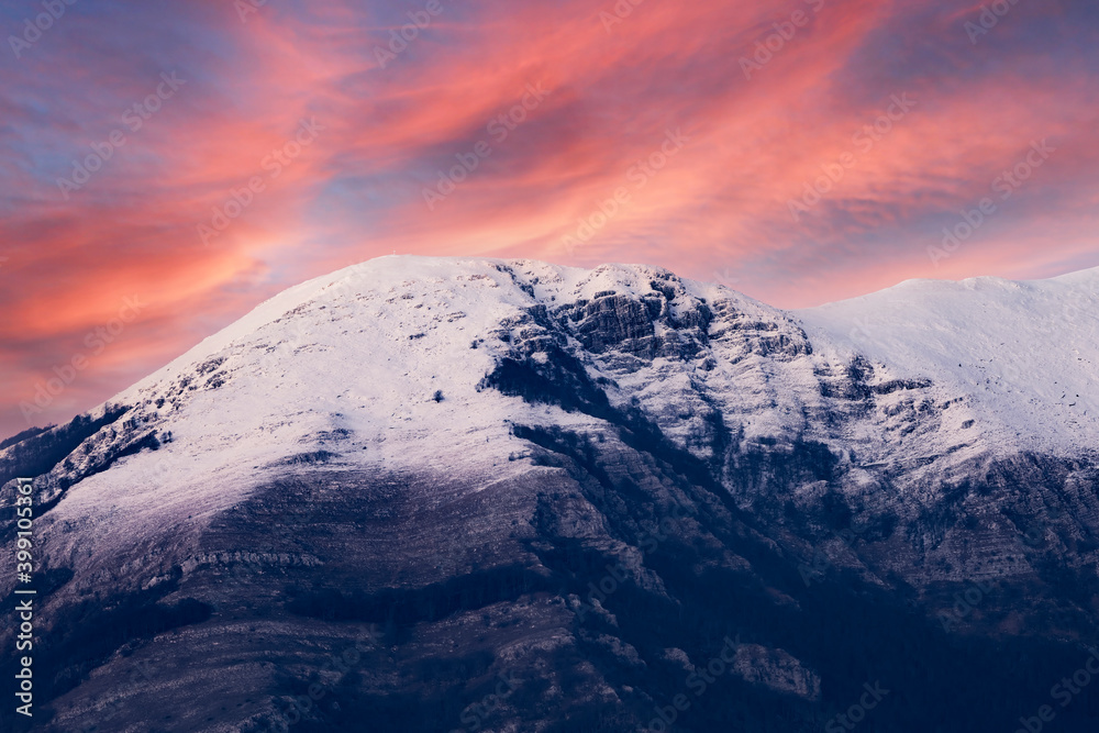 Stunning view of a snow capped mountain range during a dramatic sunset. Campocatino, Frosinone, Italy.