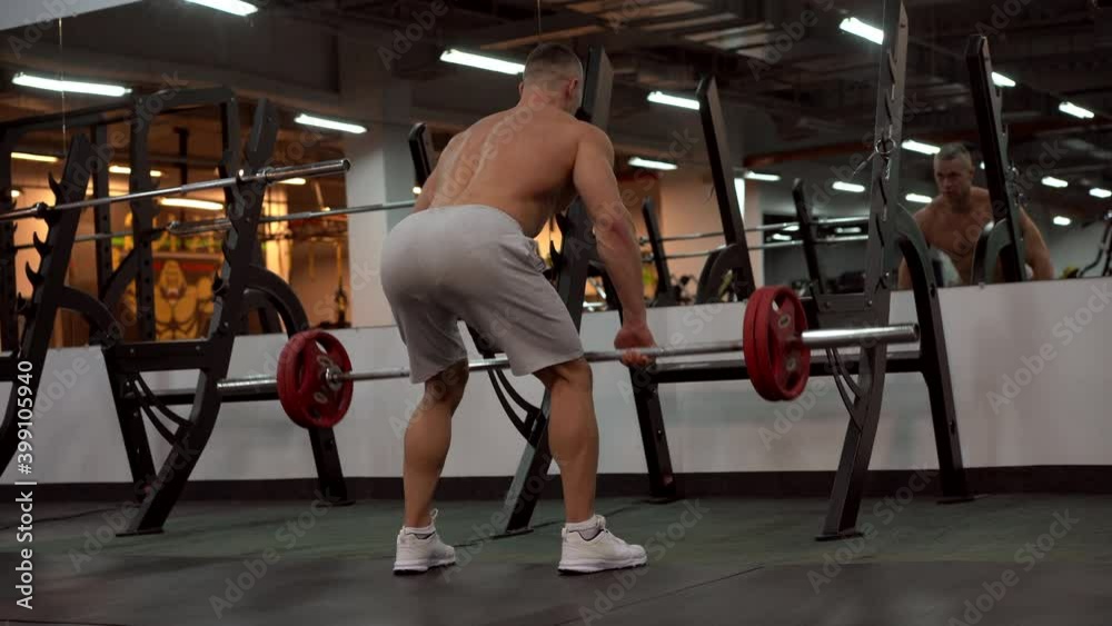 Muscular athletic bodybuilder fitness model standing in front of mirror training lift barbell indoor gym Sport fitness healthy lifestyle concept Caucasian person muscular body Functional training Muscular athletic bodybuilder fitness model standing in front of mirror training lift barbell indoor gym Sport fitness healthy lifestyle concept Caucasian person muscular body Functional training