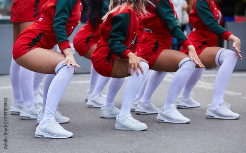 body parts of a teenage Caucasian cheerleader girl in a red uniform doing dance moves.