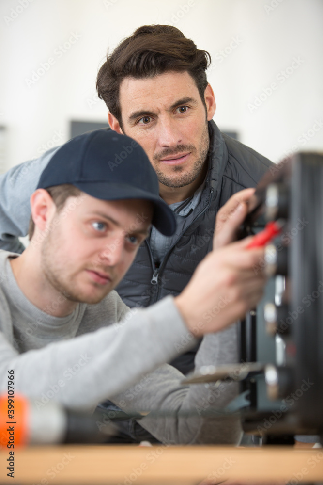 two men checking a broken oven two men checking a broken oven