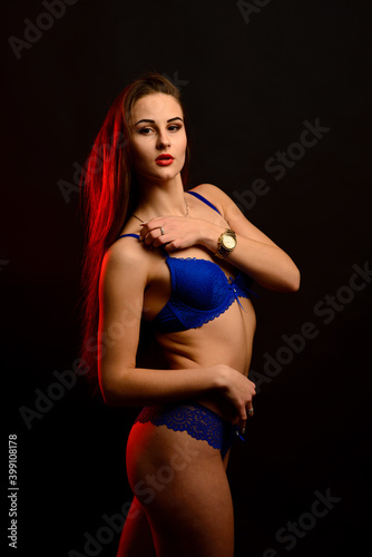 Beautiful sexy woman in blue underwear on dark background, perfect female body, studio shot