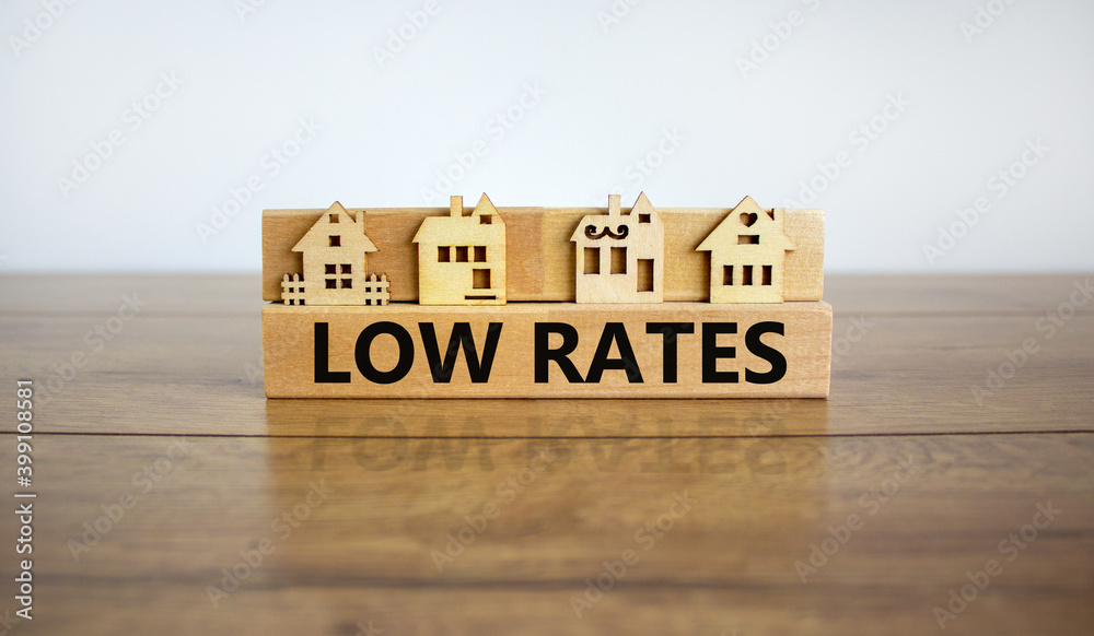 Low rates symbol. Wooden blocks form the words 'loe rates', miniature house, wooden table. Beautiful white background, copy space. Business and low rates concept. Low rates symbol. Wooden blocks form the words 'loe rates', miniature house, wooden table. Beautiful white background, copy space. Business and low rates concept.