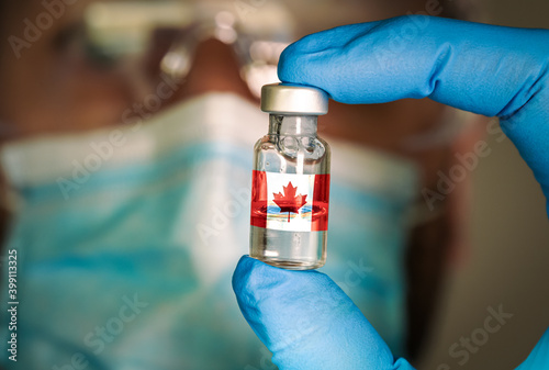 Canvas Print Close-up of medical vial with the flag of Canada and a blurred doctor on the background