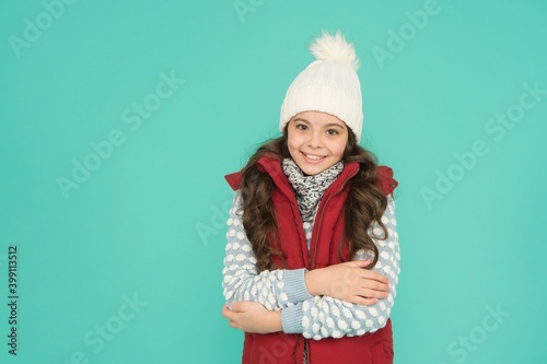 cheerful kid in warm winter clothing of knitted hat scarf and sweater on new year holidays, winter season