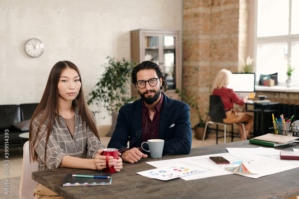 Young Asian female office worker and her male colleague having coffee at break