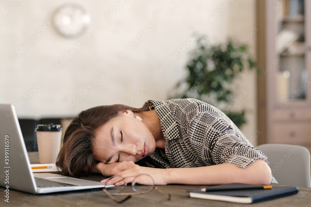 Young exhausted businesswoman in formalwear keeping head on hand while napping Young exhausted businesswoman in formalwear keeping head on hand while napping